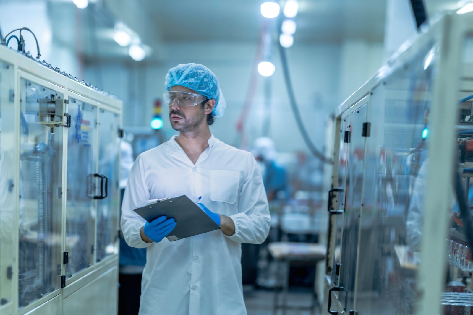 A professional in a lab surrounded by advanced machinery, demonstrating Pharmaceutical Robotics Integration in action.