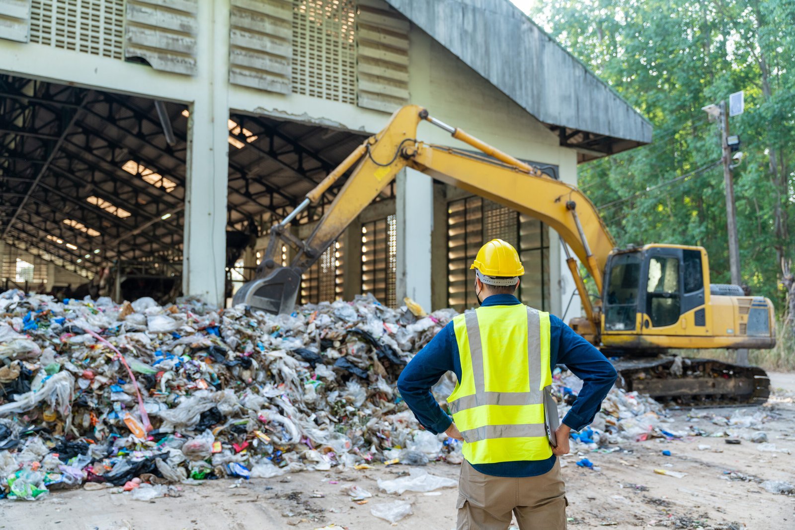 Construction robot crane arm lifting building waste into a trash container at an urban site, powered by Recycling & Waste Management Robotics.