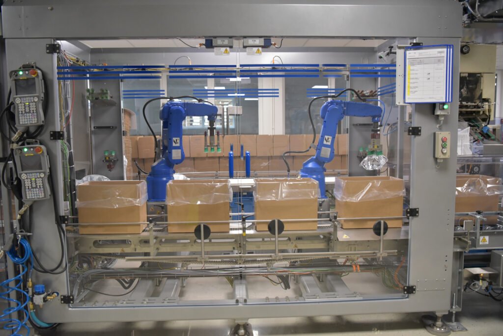Robots in a modern pharmaceutical factory handling the transport and packaging of dialysis bags, showcasing Pharmaceutical Robotics Integration to enhance efficiency, precision, and compliance in medicine production.
