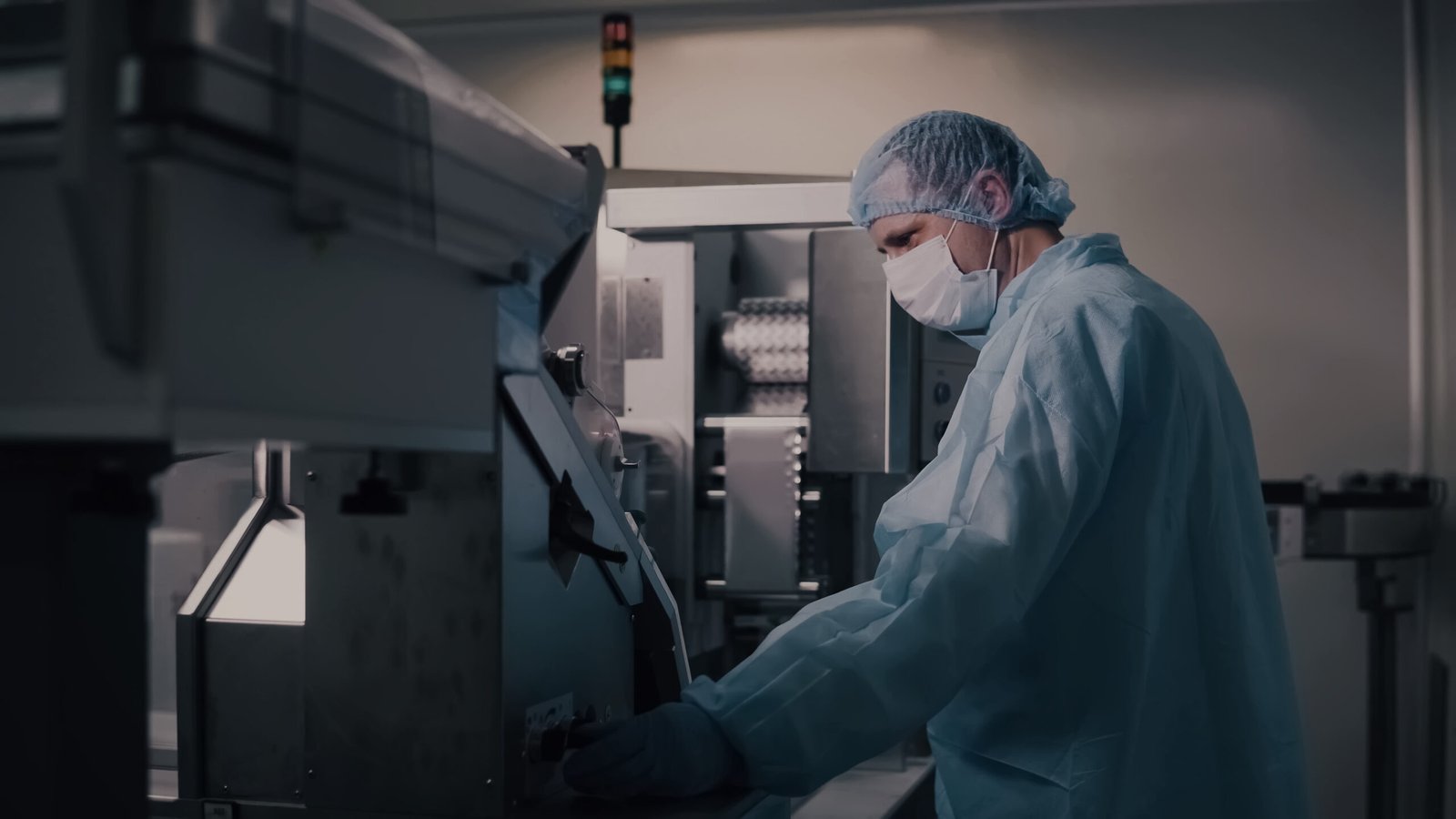 Engineer operating pharmaceutical equipment in a high-tech facility, showcasing Pharmaceutical Robotics Integration in automated drug manufacturing and production control.