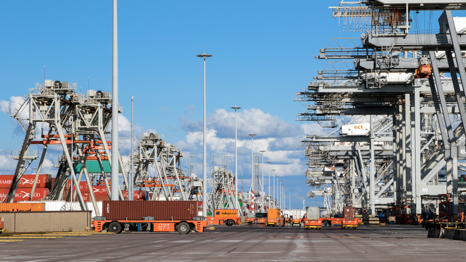 VDL AGV effortlessly moves a shipping container across the Port of Rotterdam, streamlining logistics with autonomous technology.