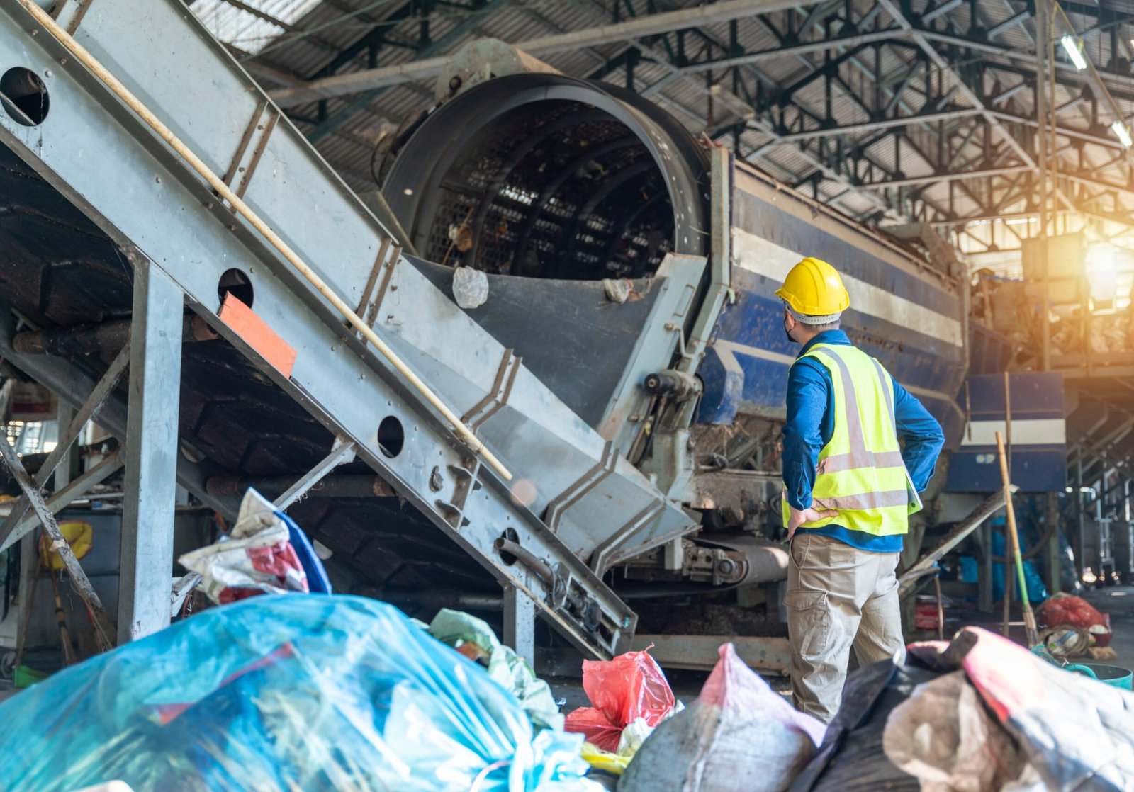 An Engineer in protective checking automated systems, recycling industry, waste separation plant.